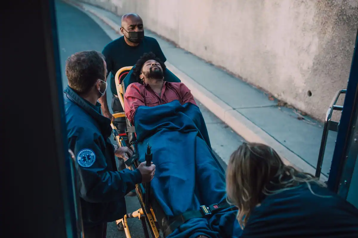 Pacient dus pe targă de echipajul unei ambulanțe, pe o rampă de spital
